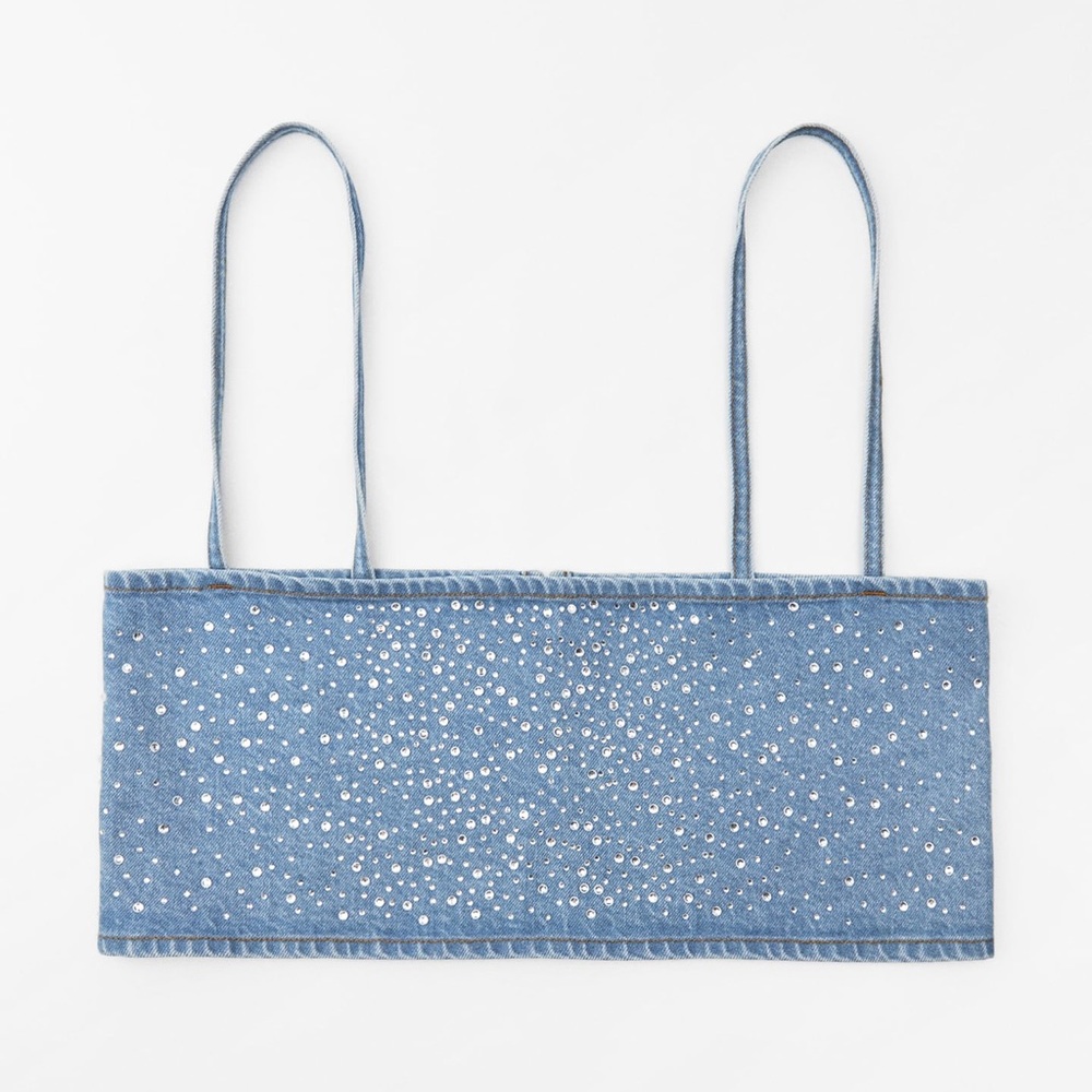 Top made of denim. Straight neckline and spaghetti straps. Metal hook closure